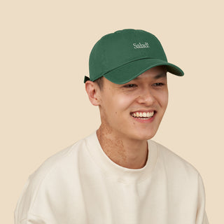 Smiling person wearing Salad! Collection Hat in Kale with "Salad!" embroidered across the front.