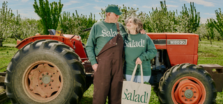 A couple looking happily at each other wearing Salad! collection apparel and accessories.