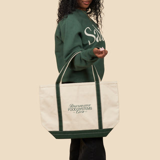 Person wearing Salad! Crewneck sweatshirt with Regenerative Food Systems Club Boat Tote on their arm.