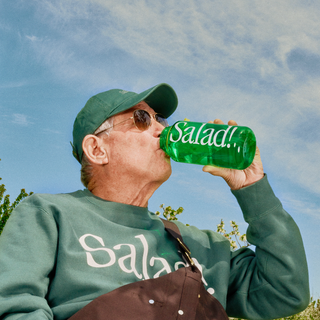 Person drinking from Salad! Collection Nalgene Bottle while wearing Salad! Collection Crewneck and Hat.